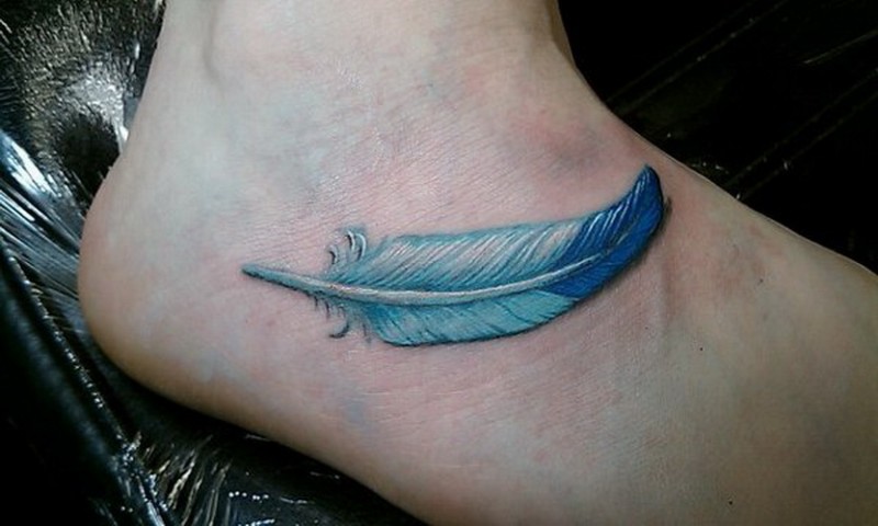 A Small Blue Feather Tattoo On The Arm A Small Blue Feather Tattoo On The Arm